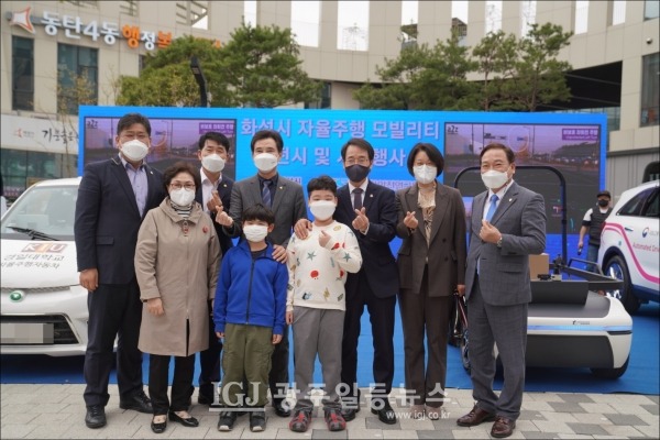 전시된 화성시 자율주행차량 앞에서 기념 촬영을 하는 모습.