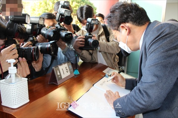 여러 카메라에 둘러쌓여 방명록에 서명하는 송영길 당대표 후보.