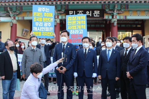민주의문 앞에서 기자들과 질의응답을 하는 송영길 당대표 후보. 보다 확실한 개혁을 요구하는 일부 당원들의 시위도 함께하고 있다.