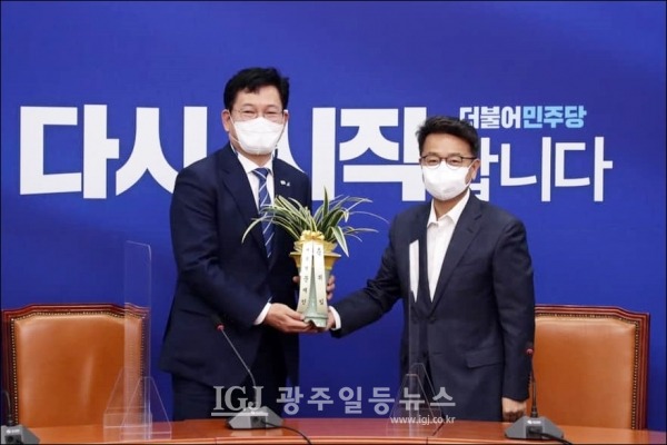 더불어민주당 송영길 대표(왼쪽)가 이철희 청와대 정무수석으로부터 문재인 대통령의 축하 난을 전달받고 기념촬영을 하고 있다.