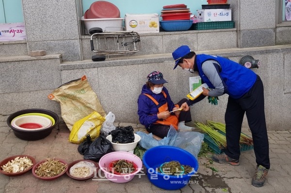 바르게살기운동 광산구협의회 김병우 회장이 12일 신가사거리와 우체국 부근에 있는 노점상들에게 마스크를 나눠주고 있다.
