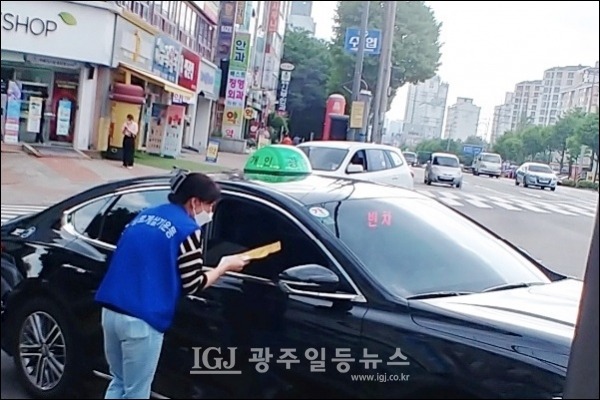 운남동 바르게살기위원회 엄기숙 여성회장이 택시 기사에게 마스크를 나눠주고 있다.