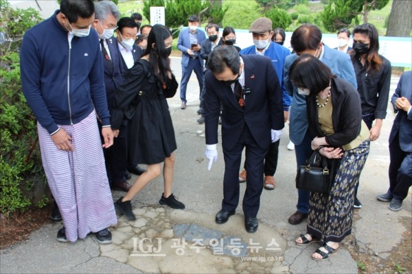 정세균 전 총리가 미얀마인들에게 전두환 표지석을 가리키며 전두환과 군부독재에 대한 얘기를 하고 있다.