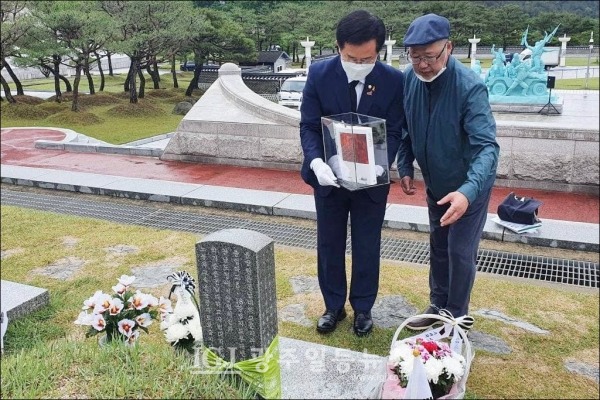 이용빈 의원과 황광우 작가가 지난 17일, 국립5‧18 민주묘지에 있는 5‧18 시민군 대변인 윤상원 열사의 묘소를 찾아 황광우 작가가 엮은 '윤상원 일기'를 헌정하고 있다.