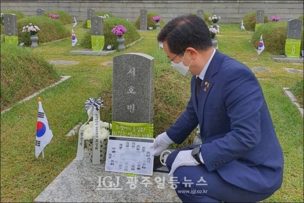 이용빈 국회의원이 5‧18 당시 전남대 학생이었던 서호빈 열사의 묘소에 영정사진을 헌정하고 있다.