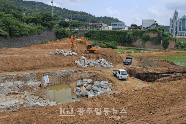 소촌저수지 복구 현장에서 자연석 쌓기로 배수로를 설치하는 모습.