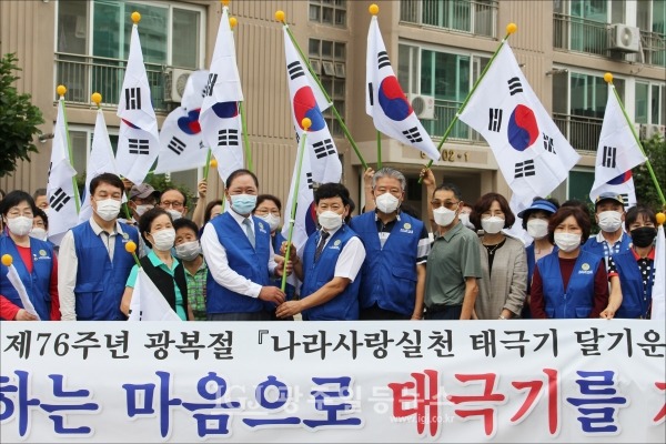 광산구 운남동 주공1단지에서 광주시협의회 구제길 회장이 광산구협의회 김병우 회장에게 태극기를 전달하며 기념 촬영을 하고 있다.