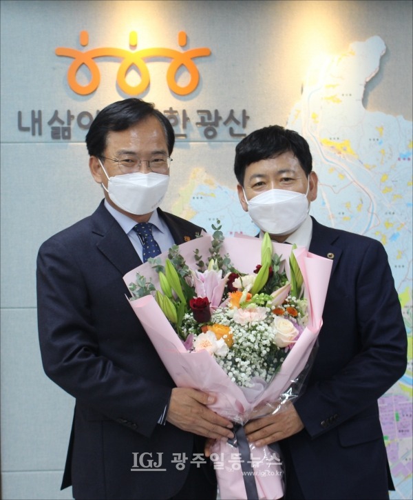 김삼호 광산구청장(왼쪽)이 지난 12월 6일 국민훈장 목련장을 수훈한 바르게살기운동 광주 광산구협의회 김병우 회장(오른쪽)을 축하하고 함께 기념 촬영을 하고 있다.