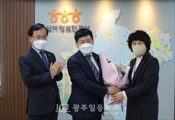 광산구청 임은진 주민자치과장이 김병우 회장에게 축하의 꽃다발을 전하는 순간 김삼호 광산구청장이 박수로 축하하고 있다. (왼쪽부터) 김삼호 광산구청장, 김병우 바르게살기 광산협의회장, 임은진 주민자치과장.