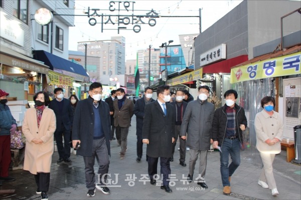 민주당 을지로위원회 진성준 위원장과 이용빈 위원 등이 김재복 상인회장의 안내를 받으며 송정역1913시장으로 들어서고 있다. (왼쪽부터) 광산구의회 김미영‧공병철 의원, 이용빈 국회의원, 진성준 국회의원, 김재복 상인회장, 광산구의회 윤혜영 의원. 바로 뒤에 광산구의회 박현석 부의장과 유영종 의원, 하석주 민원실장이 따르고 있다.