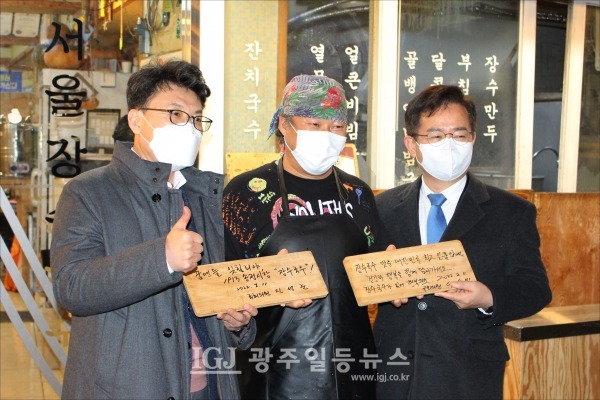 '서울장수국수'에서 식사를 하고 진성준 의원(꿈엔들 잊힐리야)과 이용빈 의원(장수국수 맛은 대한민국 최고 일품)이 나무패에 덕담을 쓴 뒤 함께 기념촬영을 하고 있다.