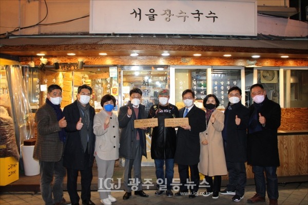 '서울장수국수'에서 식사를 마친 뒤 덕담을 쓴 팻말을 들고 기념촬영을 하고 있다.