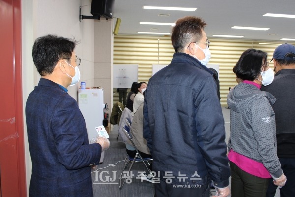 수완동 행정복지센터 3층 대회의실에 마련된 사전 투표소에서 강기정 전 정무수석(맨 왼쪽)이 신분증을 꺼내들고 줄을 서서 차례를 기다리고 있다.