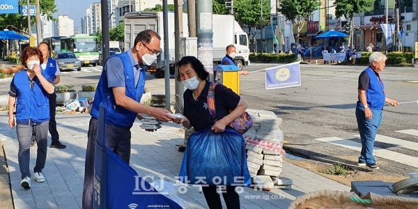광산구 바르게살기협의회 운남동 위원회 장순태 부위원장이 지나는 시민에게 소독 물티슈를 전달하며 캠페인을 펼치고 있다.