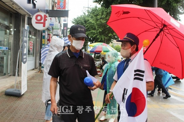 "태극기 부대가 아닙니다!" 바르게살기운동에 대한 공로로 국민훈장 목련장을 수훈한 바 있는 김병우 회장(오른쪽) 지나는 어르신께 태극기를 전해드리며 국경일에 태극기 달 것을 권하고 있다.