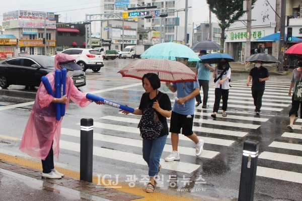 바르게살기운동 광주광역시 광산구협의회 김열화 이사가 영광통 횡단보도에서 태극기를 나눠주고 있다.