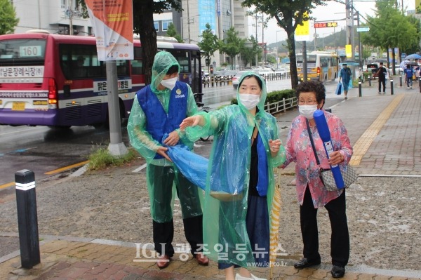 바르게살기운동 광주광역시 광산구협의회 구희숙 부회장(가운데)이 어르신에게 길을 안내하고 있다.