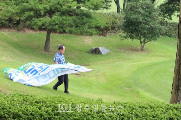 제5회 대동포럼의장배 골프대회에서 대동포럼 김성식 운영위원장이 촬영 배경으로 사용할 펼침막을 들고 티샷그린으로 이동하고 있다.