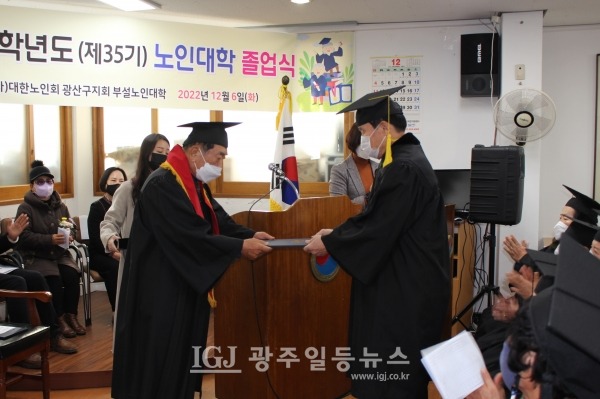 광산구 노인대학 제35기 졸업식에서 오해윤 수석부회장이 노인강령을 낭독한 뒤 임중석 학장에게 강령을 전달하고 있다.