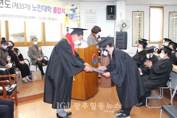 광산구 노인대학 제35기 졸업식에서 임중석 학장이 개근상을 수상한 10명의 학생을 대표한 송청자 학생에게 개근상을 수여하고 있다.