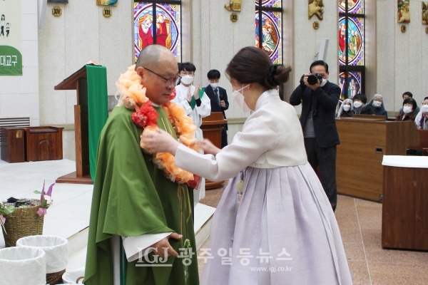 운남동성당 김란희 마리아막달레나 자매가 은경축을 맞이한 조정훈 안토니오 주임신부에게 축하 화환을 걸어준 뒤 매무새를 다듬고 있다.