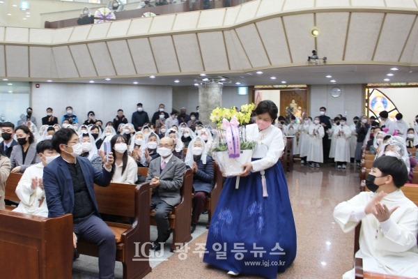 운남동성당 사목회 송영남 도미니카 부회장이 은경축을 맞이한 조정훈 주임신부를 축하하는 화분을 전달하기 위해 입장하고 있다.