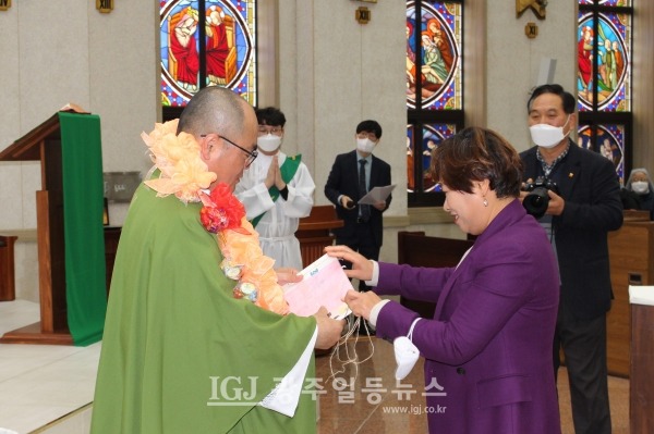 은경축을 맞이한 조정훈 안토니오 신부에게 박미영 카타리나 자매가 신자들의 소망록을 전하고 있다.
