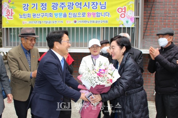 강기정 광주광역시장이 광산구 노인지회 어르신들께 받은 꽃다발을 '어르신들 잘 모시라'라면서 지역구 구의원인 광산구의회 양만주 의원에게 전하고 있다.