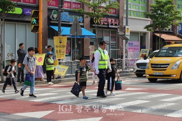 이정선 광주광역시 교육감이 등교하는 광산구 선운초등학교 어린이들의 손을 잡과 선운초 정문과 이지더원 아파트 사이의 횡단보도를 건너고 있다.