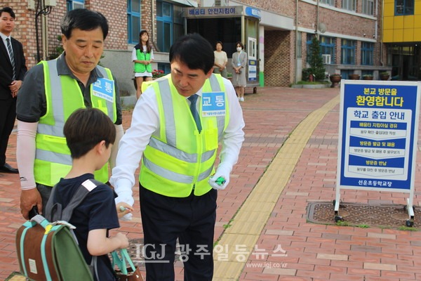 이정선 교육감이 등교하는 어린이에게 선물(밴드, 지우개)을 전하고 있다. 바로 옆애 어울림사랑나눔봉사회 이찬호 회장이 함께하고 있다.