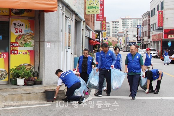 월곡1동 바르게살기위원회가 월곡시장 인근 이면도로와 골목길 줍깅 활동을 하던 중, 왔구나포차 앞을 지나는 모습. 박균택 변호사가 쪼고리고 앉아 담배꽁초를 줍고 있다.