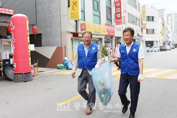 '줍깅'답게 함께 걸으며 이야기도 하고 쓰레기도 줍는 활동 중인 이성호 무등일보 부국장(왼쪽)과 박균택 변호사(오른쪽)가 환한 표정으로 카메라 앞을 지나고 있다.