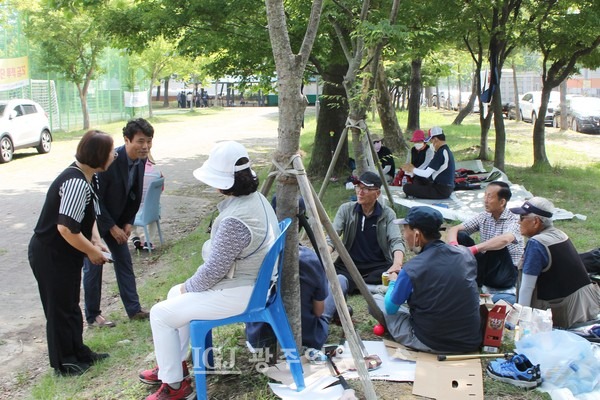 '광산구청장기 그라운드골프대회'에서 정희성 진보당 광산구갑지역위원장이 경기장 주변에서 쉬거나 관전하는 어르신들에게 인사를 하고 있다.