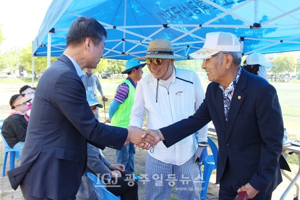 박균택 변호사가 '광산구청장기 그라운드골프대회'를 찾자 대회를 주관한 (사)대한노인회 광산구지회 유한봉 회장이 환한 표정으로 악수를 하고 있다. 가운데는 박하경 광주광역시노인지도자대학장.