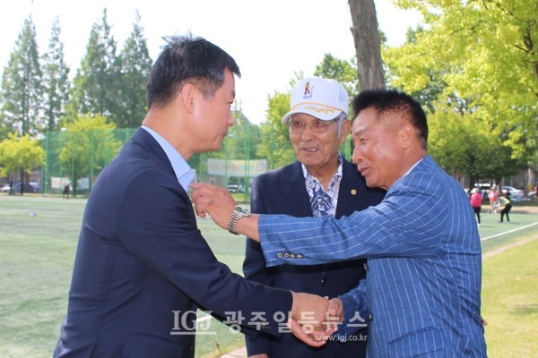 광산구체육회 배영모 회장(오른쪽)이 박규택 이사(왼쪽)와 악수하며 옷 매무새를 만져주고 있다. 가운데는 유한봉 노인지회장.