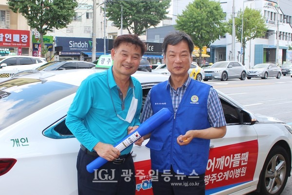 박균택 변호사를 보고 차를 멈춘 개인택시 기사에게 태극기를 건네 준 후 기념 촬영을 하는 모습.