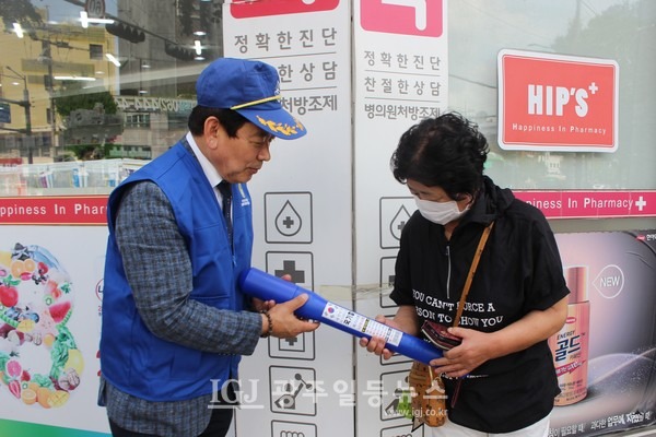바르게살기운동 광산구협의회 김병우 회장이 영광통사거리에서 길가는 시민에게 태극기를 나눠주고 있다.
