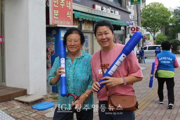 광산구 바르게게 나눠준 태극기를 든 모녀가 흐뭇한 표정으로 카메라를 응시하고 있다.