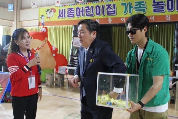 최은 세종어린이집 원장의 원활한 진행 아래, 김병내 남구청장이 세종어린이집 한마음 가족운동회에서 행운권 추첨을 진행하고 있다.