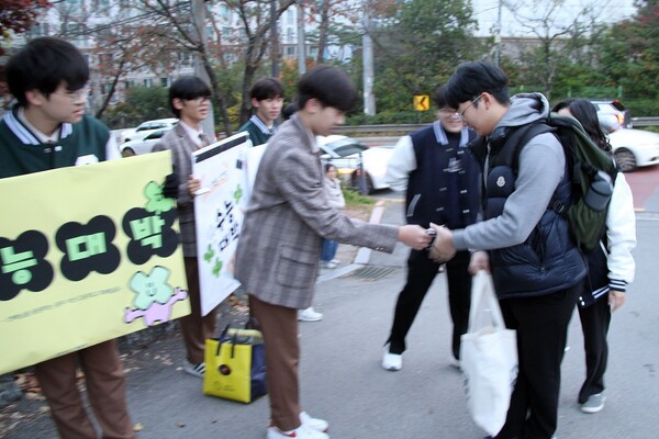 13일 오전 문성고등학교 시험장 앞에서 후배 학생들이 수험생들에게 작은 선물을 나누며 응원의 메시지를 전하고 있다.