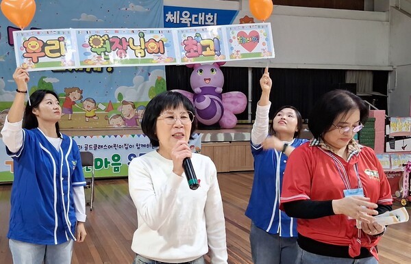 (흰옷) 윤보미 골드클래스 어린이집 원장은 가족 사랑 한마음 운동회에 참석해 "오늘 하루만큼은 승부보다 가족이 함께 뛰고, 웃고, 응원하는 마음 자체를 더 중요하게 느끼셨으면 한다. 끝까지 즐겁고 안전하게 참여해 주시고, 아이들에게 많은 격려와 박수 부탁드린다."라고 인사말을 하고 있다.