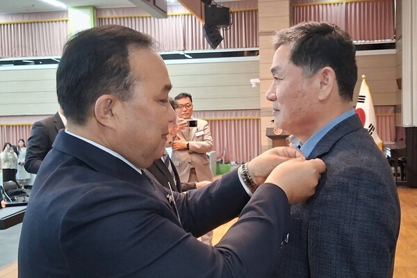 박성구 민주평화통일자문회의광주광산구협의회장은  제22기 민주평화통일자문회의 광주광산구협의회 출범식에서 이재명 민주평통 의장(대통령)을 대신해 송남수 상임위원에게 뱃지를 전수하고 있다.