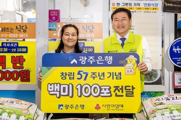 고병일 광주은행장은 창립 57주년 맞아 김윤경 해뜨는 식당 대표에게 백미 100포를 전달한 후 기념촬영을 하고 있다.