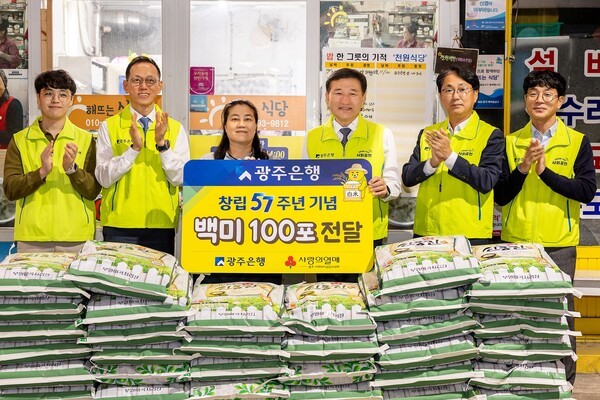 고병일 광주은행장은 창립 57주년 맞아 김윤경 해뜨는 식당 대표에게 백미 100포를 전달한 후 직원들과 함께  기념촬영을 하고 있다.